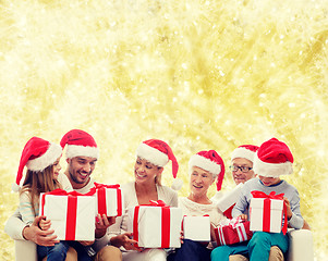 Image showing happy family in santa helper hats with gift boxes