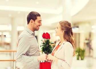 Image showing happy young couple with flowers in mall