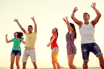 Image showing smiling friends dancing on summer beach