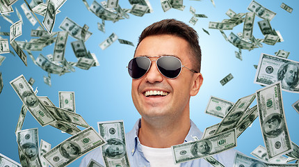 Image showing happy man in sunglasses with falling dollar money