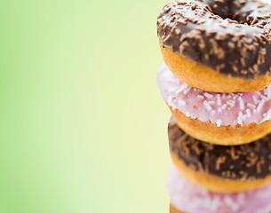 Image showing close up of glazed donuts pile over green