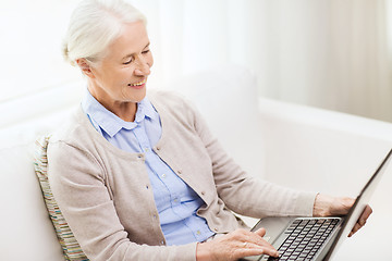 Image showing happy senior woman with laptop at home