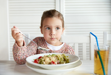 Image showing little girl eating pasta for dinner at restaurant