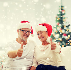 Image showing happy senior couple in santa helper hats