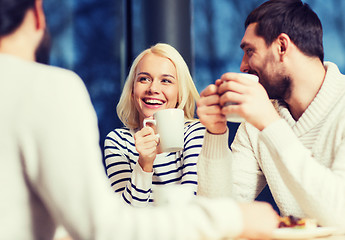 Image showing happy friends meeting and drinking tea or coffee