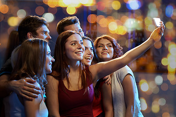 Image showing friends with smartphone taking selfie in club