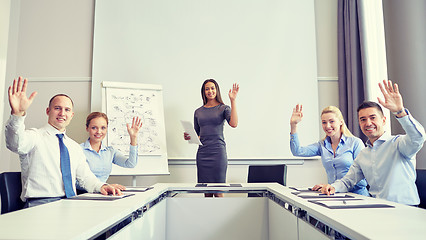 Image showing group of businesspeople waving hands in office
