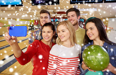 Image showing happy friends with smartphone in bowling club