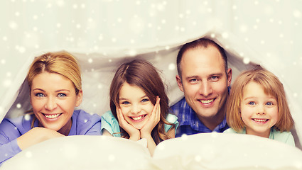 Image showing happy family with two kids under blanket at home