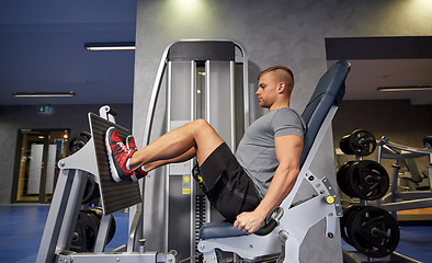 Image showing man flexing leg muscles on gym machine