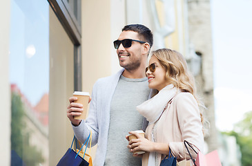 Image showing happy couple with shopping bags and coffee in city