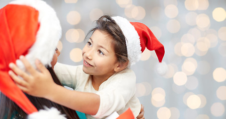 Image showing happy mother and little girl in santa hats