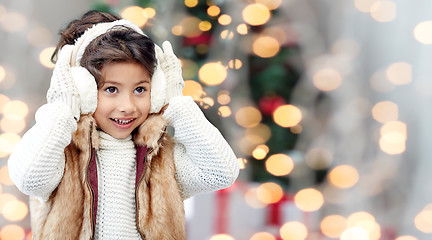 Image showing happy little girl wearing earmuffs at christmas