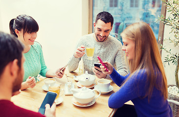 Image showing group of friends with smartphones meeting at cafe