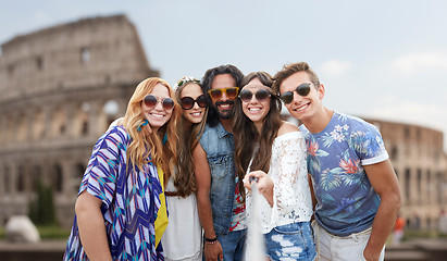 Image showing happy hippie friends with selfie stick at coliseum