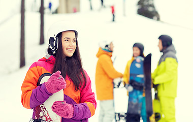 Image showing happy friends in helmets with snowboards