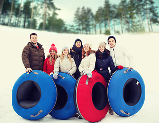 Image showing group of smiling friends with snow tubes