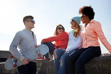 Image showing happy teenage friends with skateboard on street