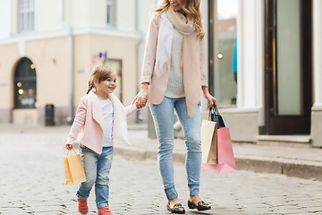 Image showing happy mother and child with shopping bags in city