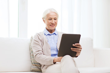 Image showing happy senior woman with tablet pc at home