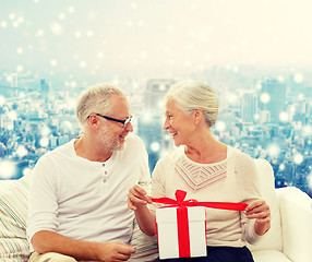 Image showing happy senior couple with gift box at home