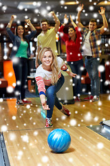 Image showing happy young woman throwing ball in bowling club