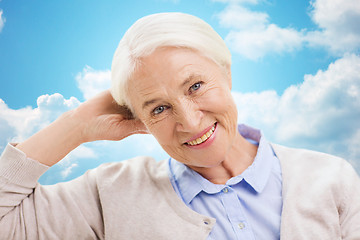 Image showing happy senior woman over blue sky and clouds