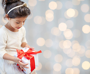 Image showing happy little girl with present over lights