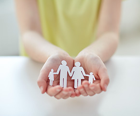 Image showing close up of child hands with paper family cutout