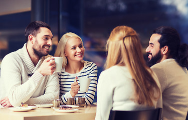 Image showing happy friends meeting and drinking tea or coffee