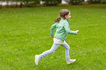 Image showing happy little girl running on green summer field