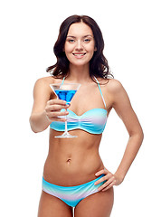 Image showing happy young woman in swimsuit drinking cocktail