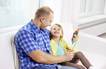 Image showing happy father and daughter sitting on sofa at home