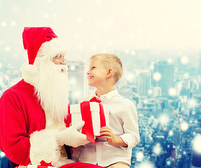 Image showing smiling little boy with santa claus and gifts