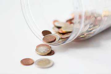 Image showing close up of euro coins in open glass jar on table
