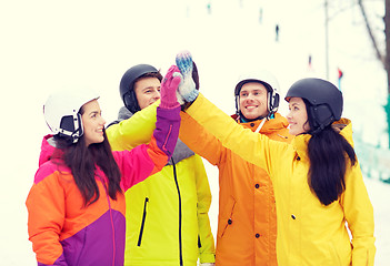 Image showing happy friends in helmets making high five