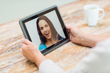 Image showing senior woman with photo on tablet pc at home