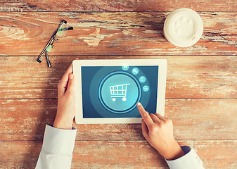 Image showing close up of hands with tablet pc and shopping cart