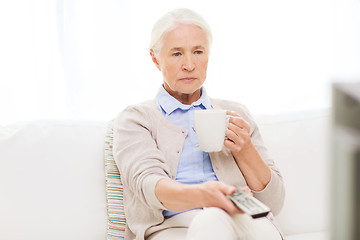 Image showing senior woman watching tv and drinking tea at home