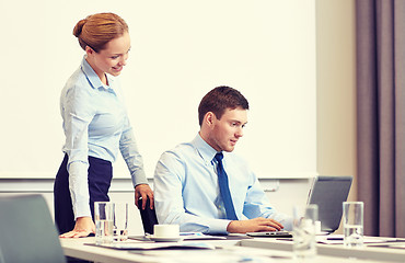 Image showing businessman and secretary with laptop in office