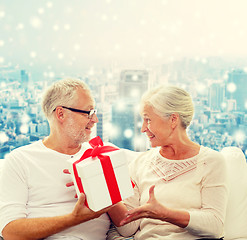 Image showing happy senior couple with gift box at home