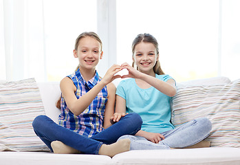 Image showing happy little girls showing heart shape hand sign