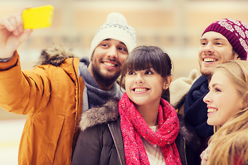 Image showing happy friends taking selfie on skating rink