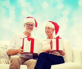 Image showing happy senior couple in santa hats with gift boxes