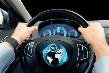 Image showing close up of man driving car with globe on screen