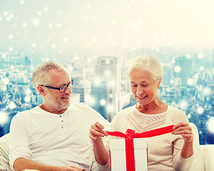 Image showing happy senior couple with gift box at home