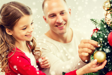 Image showing smiling family decorating christmas tree at home