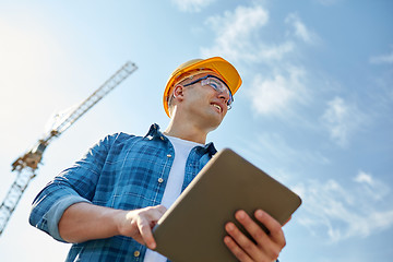 Image showing builder in hardhat with tablet pc at construction