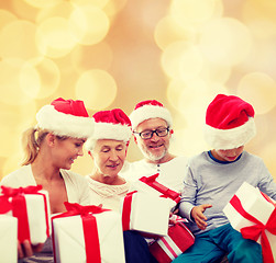 Image showing happy family in santa helper hats with gift boxes