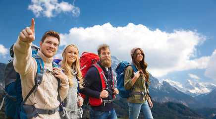 Image showing happy friends with backpacks hiking over mountains